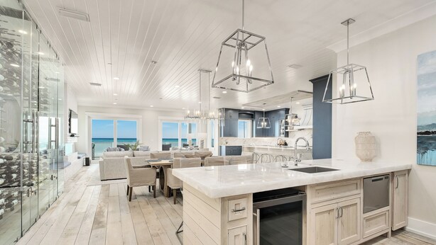 A modern kitchen with a large island, pendant lights, and a view of the ocean. - Best of the Best! Gulf Front with Heated Pool, Private Gym, Private Elevator (Panama City Beach)