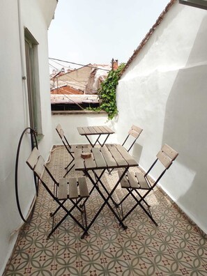 Enjoy a tranquil outdoor space with a geometric-patterned floor, wooden table, and comfortable seating for four.