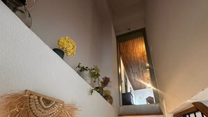 Una escalera con escalones de madera y un tapiz de pared tejido a mano.