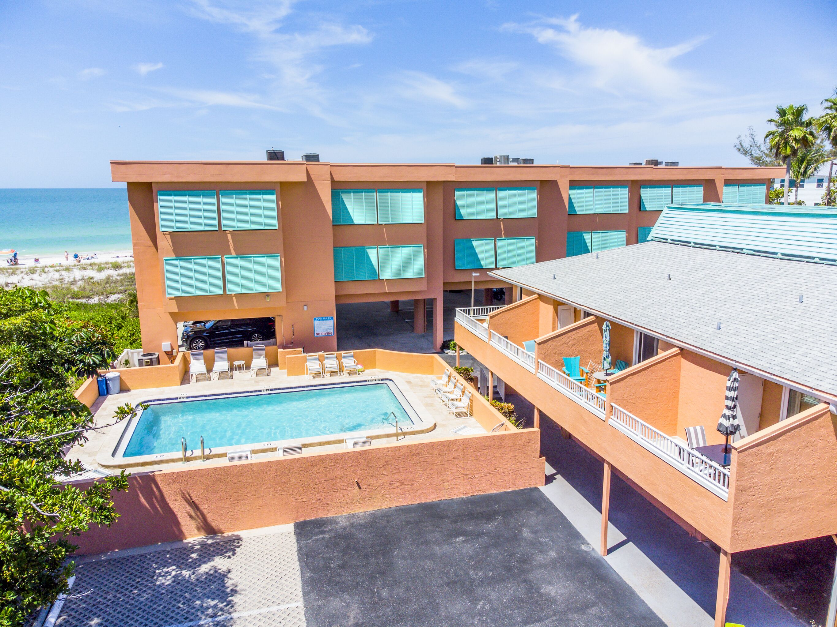 A hotel with a pool, multiple balconies, and a view of the beach.