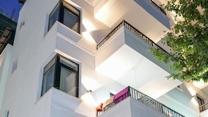 Een modern hotel met een opvallend “HOTEL”-bord, meerdere balkons en een goed verlichte entree.