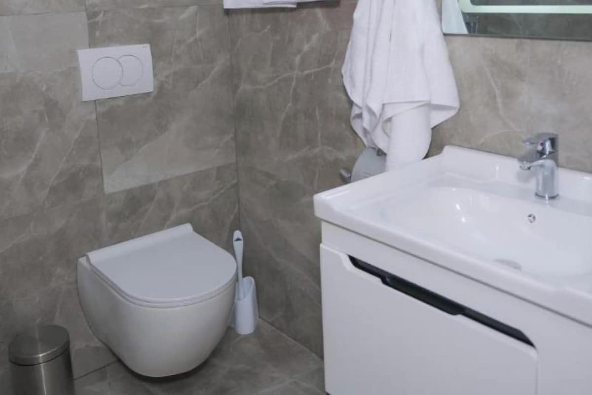 A modern bathroom with a toilet, bidet, and sink.