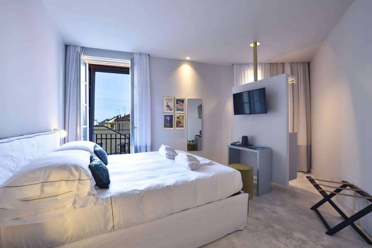 Et moderne hotelværelse med en stor seng, et fjernsyn og en balkon.