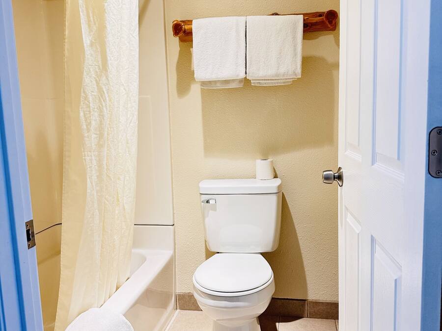 Ein Badezimmer mit Toilette, einer Duschkabine und zwei Handtüchern an einem Halter.