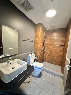 Uma casa de banho moderna com lavatório, sanita e chuveiro.