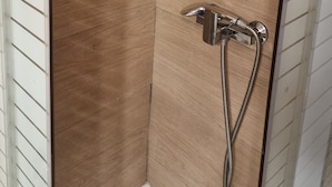 A shower area with a wooden wall and a chrome showerhead. - athens.apartotel.4 (Athens)