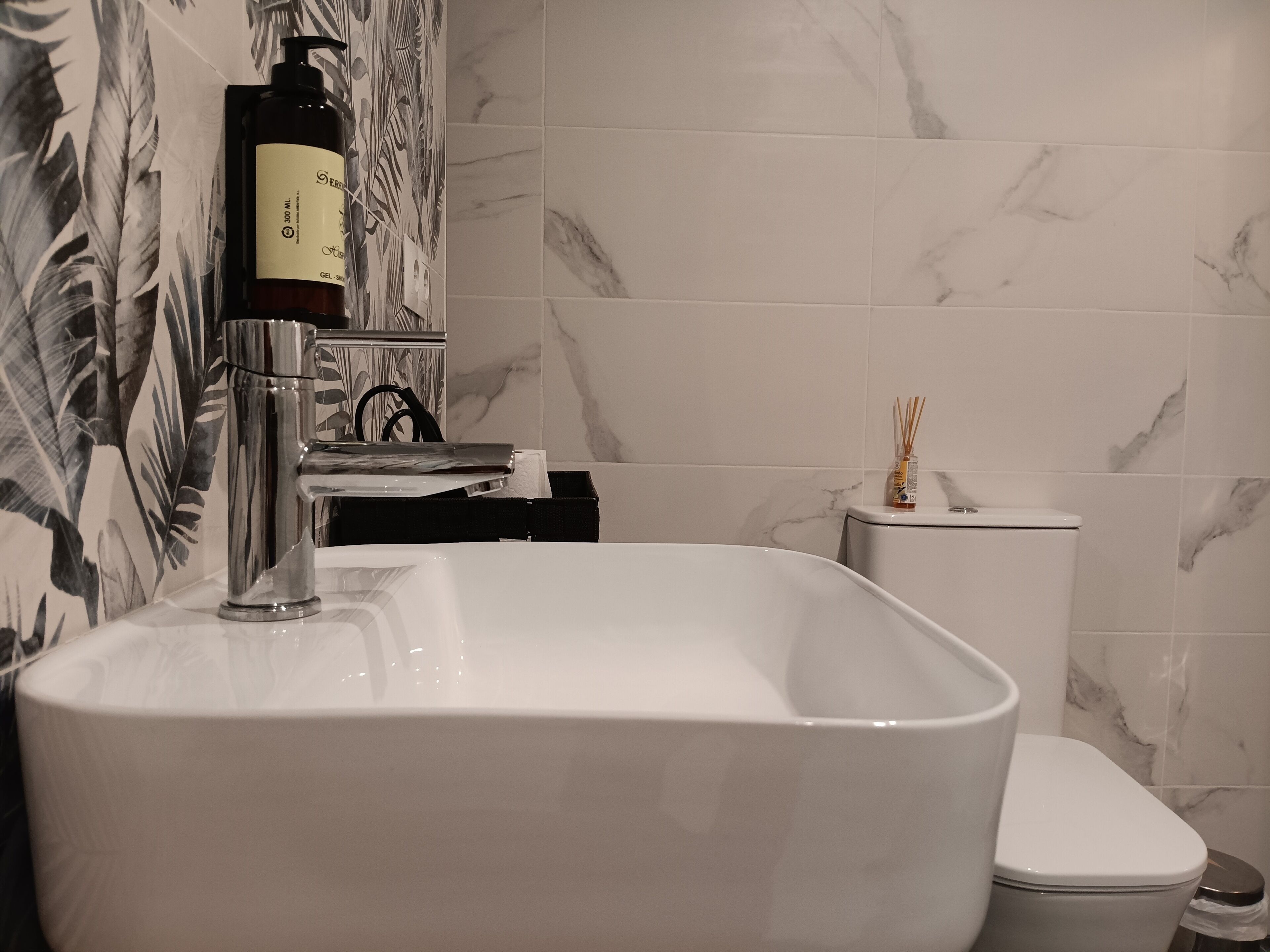 Un baño con una bañera blanca grande, un inodoro y un lavamanos instalado en la pared.