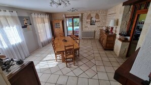 Zona pranzo con tavolo e sedie in legno, un armadietto e un termosifone.
