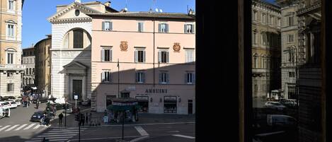 A building with a prominent entrance, a sign reading "ANSUINI," and a street view with vehicles and pedestrians.
