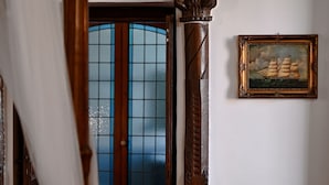 Ein Zimmer mit Holztür, einem gerahmten Gemälde und einer hölzernen Bank.