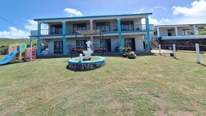 A two-story building with a pool, outdoor seating, and a children's play area. - BELLE ÉTOILE OCEAN (Rodrigues Island)