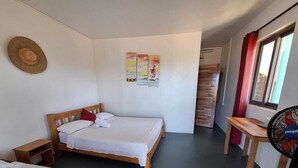 A room with two single beds, a wooden desk, a standing fan, and a straw hat on the wall. - BELLE ÉTOILE OCEAN (Rodrigues Island)