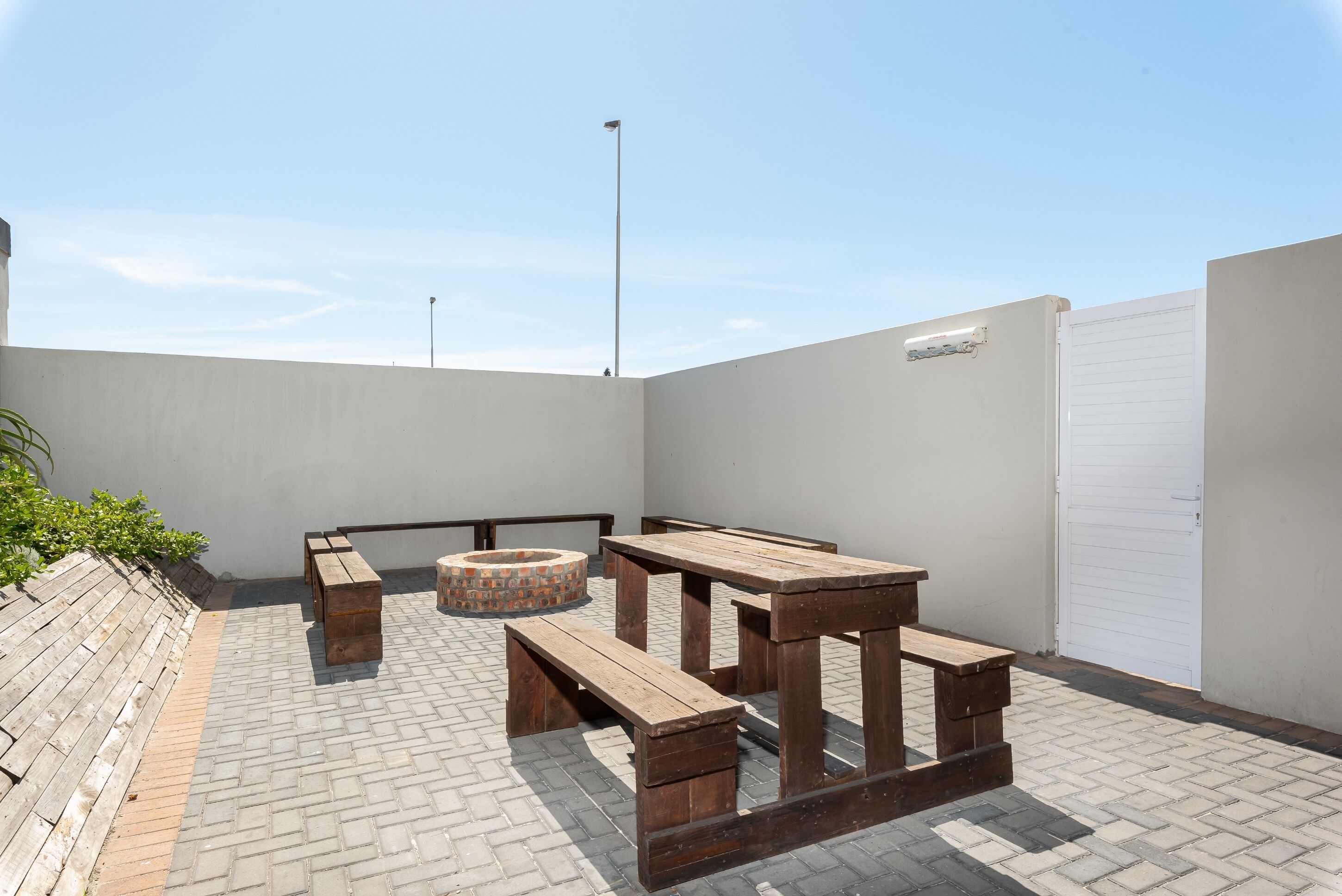 A rooftop patio with wooden benches and a fire pit.