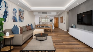 Una sala de estar moderna con un sofá, una mesita de centro y una obra de arte en la pared.