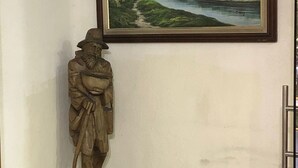 A statue on a pedestal with a framed landscape painting above it. - Hostal Iñaquito (Quito)