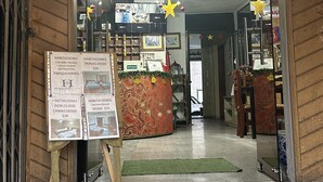 A hotel entrance with a reception desk, a signboard with room rates, and a decorative ceiling. - Hostal Iñaquito (Quito)