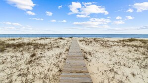 A wooden pathway leading to a beach with sand dunes and a clear blue sky. - Angler's Nook: Stunning Beachfront Home, Private Pool, Pet-Friendly, Sleeps 12 (Indian Pass)