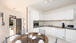 A modern kitchen with white cabinets, a built-in oven, and a microwave. - Villa Cavaco - Four Bedroom Villa, Sleeps 8 (Quarteira)
