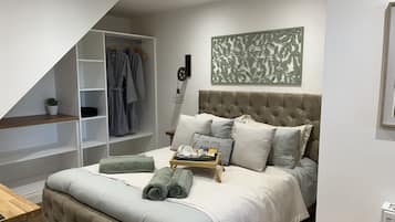 A bedroom with a bed, a wardrobe, a bedside table, and a decorative wall piece.