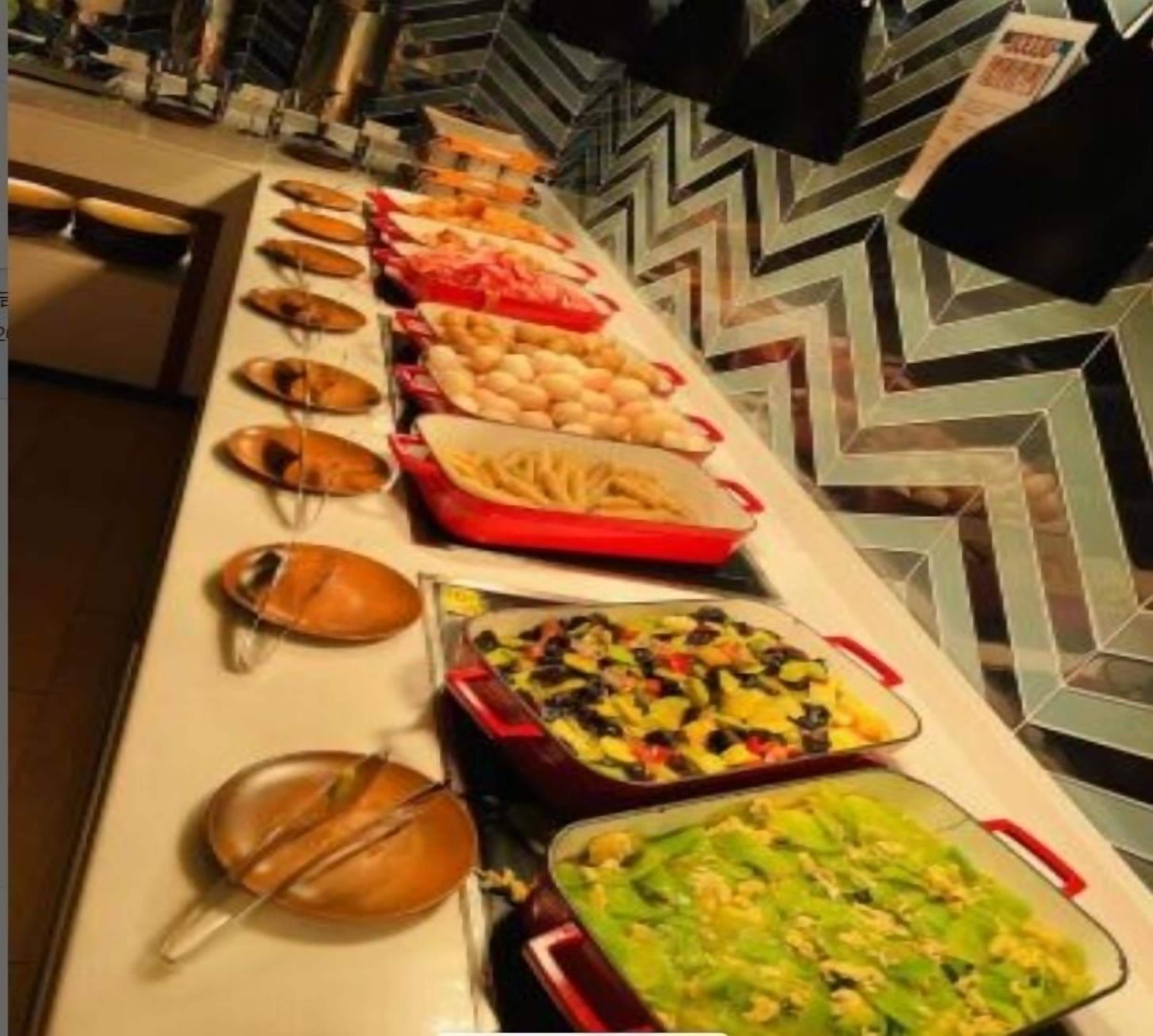 A buffet with various dishes including pasta, salads, and other foods.