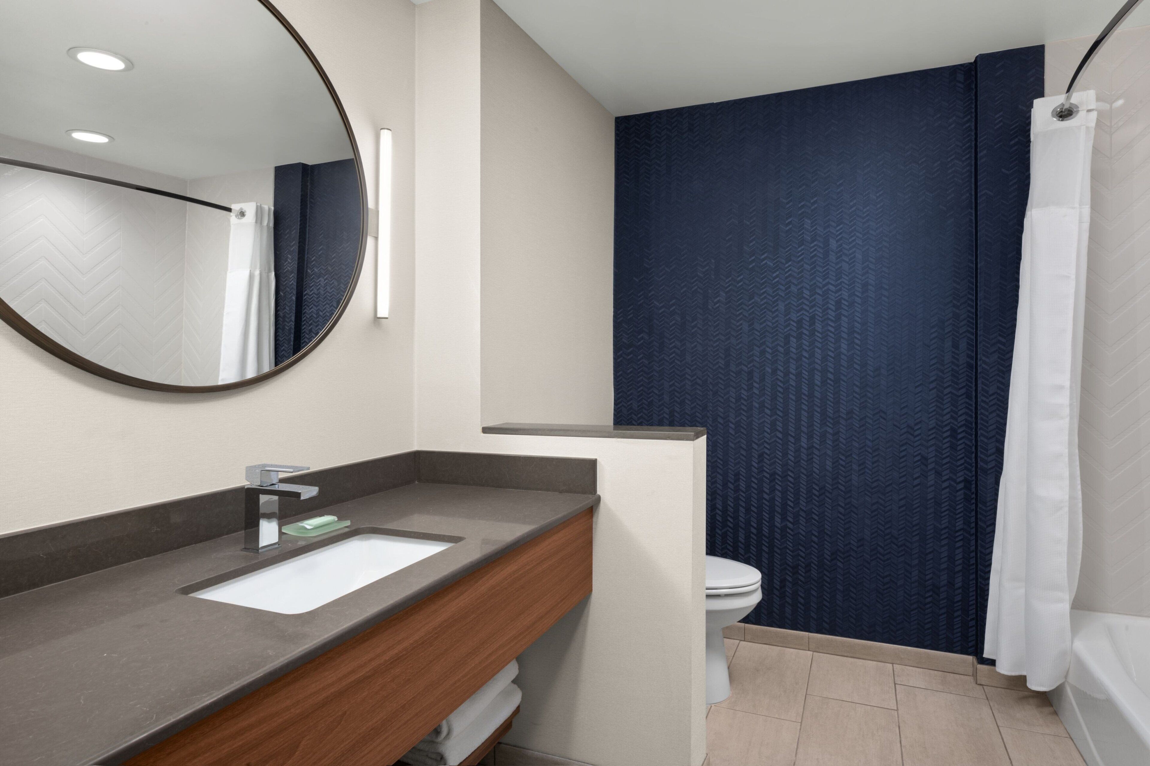 Un bagno moderno con lavabo, specchio, water e servizi igienici.