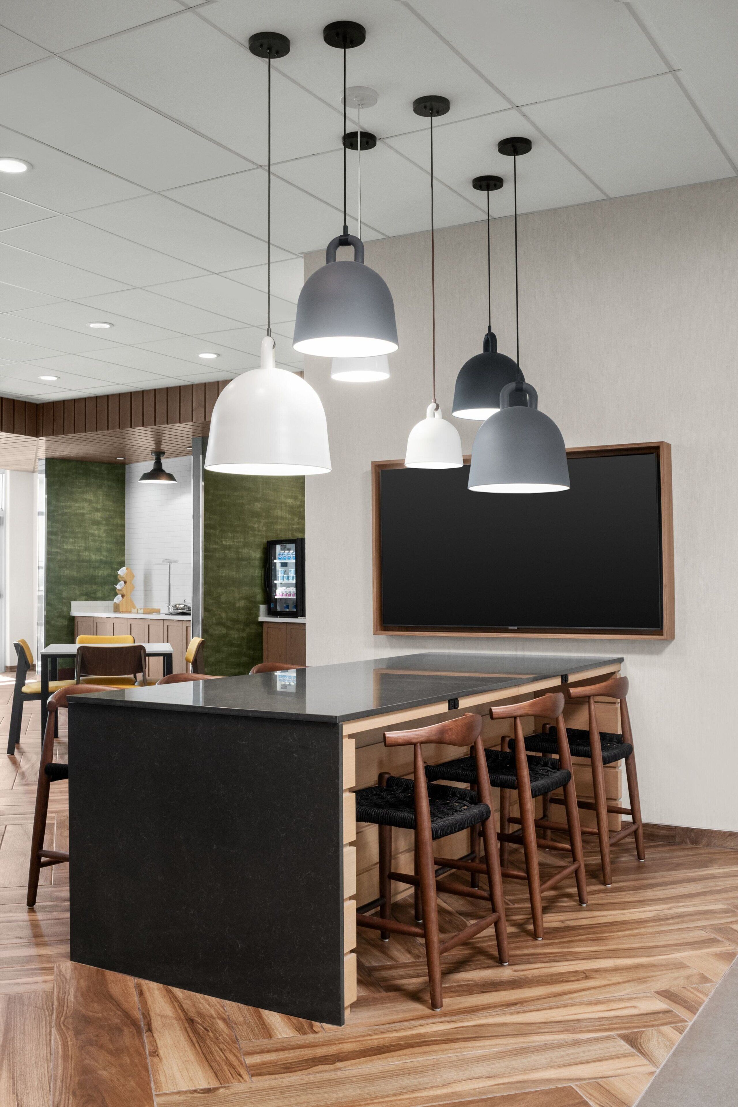 A modern kitchen with a central island, pendant lighting, and a large blackboard on the wall.