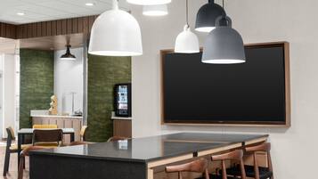 A modern kitchen with a central island, pendant lighting, and a large blackboard on the wall.