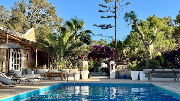 A pool area with lounge chairs and a stone building. - RIAD EUCALYPTUS, ETHNIC HOTEL (Essaouira)