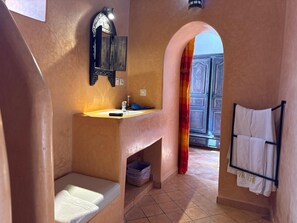 A compact bathroom with a sink, mirror, and towel rack.