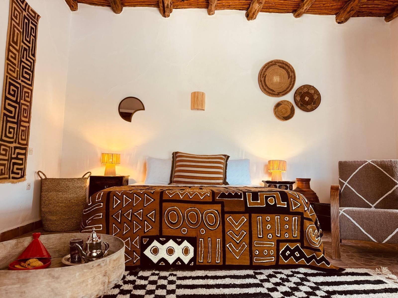 Une chambre confortable avec un lit, deux tables de chevet, une chaise et un tapis décoratif.