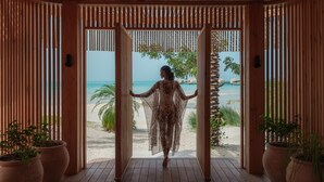 Una construcció de fusta amb vista a una platja i palmeres.
