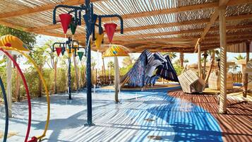 Children can play under the shaded pergola with swings and climbing frames.