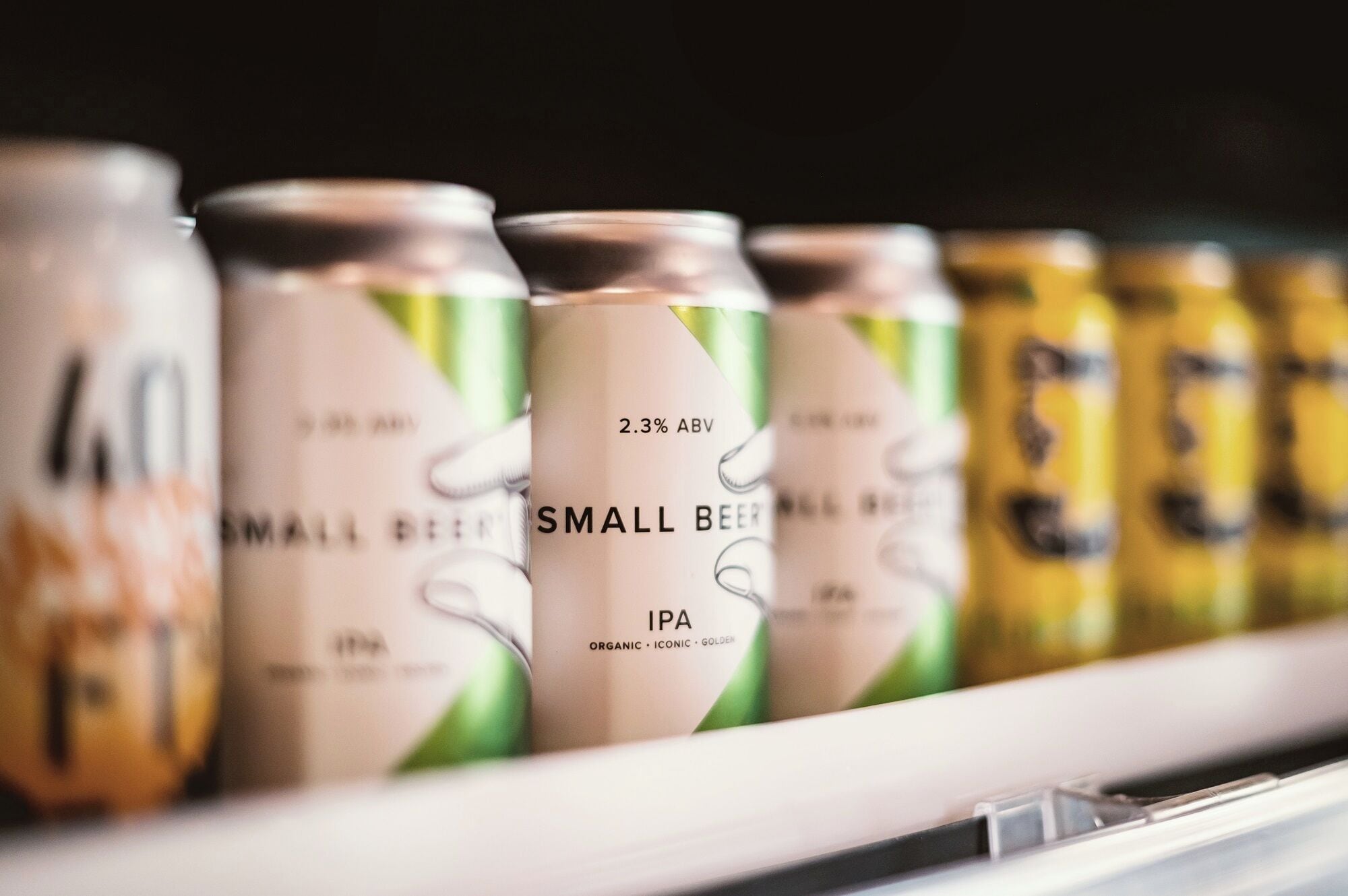 A row of beverage cans on a shelf.