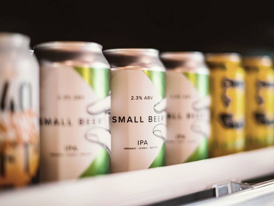 A row of beverage cans on a shelf.
