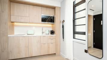 Una cocina moderna con armarios de madera, microondas integrado, tostadora y hervidor.