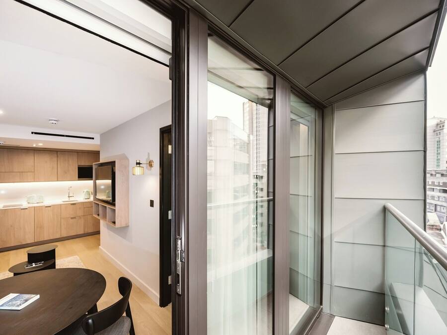 Um apartamento moderno com cozinha, área de refeições e varanda com vista para a cidade.