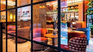 A modern hotel lobby with a bar area, seating arrangements, and a decorative wall. - Wilde Aparthotels London Liverpool St.  (London)