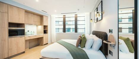 A modern bedroom with a built-in wardrobe, a large window, and a bedside table with a lamp.