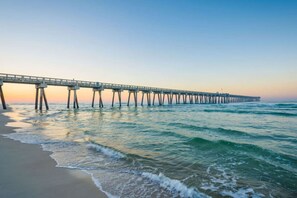 A pier extending into the water with a clear sky above.