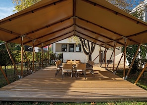 Enjoy al fresco dining under a spacious canopy, surrounded by lush greenery.