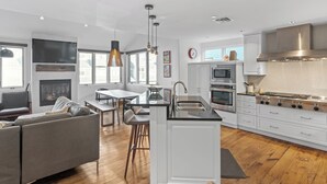 Una cocina moderna con armarios blancos, electrodomésticos de acero inoxidable y una isla central.