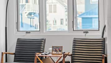 Une pièce avec deux fauteuils en cuir, une table en bois et un lampadaire.