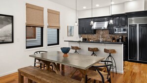 A modern kitchen with dark cabinets, a central island, and pendant lighting.