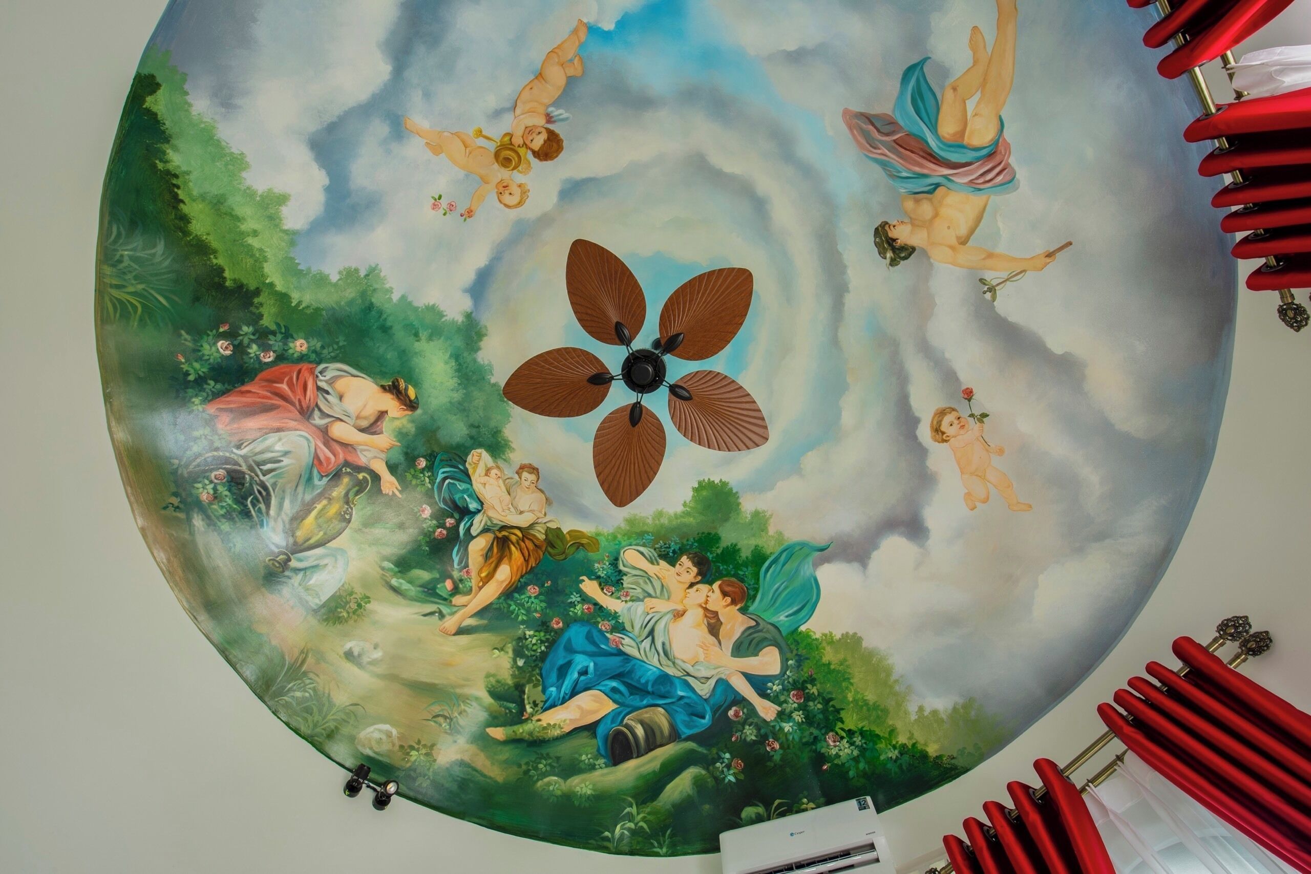 A circular mural with classical figures and a central fan.