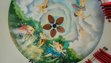 A circular mural with classical figures and a central fan.