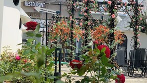 A restaurant with a sign 'DREAMY - MÔNG MÔ' and a garden with roses and climbing plants. - Trulli Villa Homestay (Don Duong)
