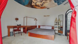A bedroom with a large bed, a desk, a chair, a wardrobe, a mirror, and a ceiling mural. - Trulli Villa Homestay (Don Duong)