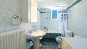 A bathroom with a sink, toilet, and bathtub. - Three Bedroom Apartment 7-9 Adults First Floor (Paros)