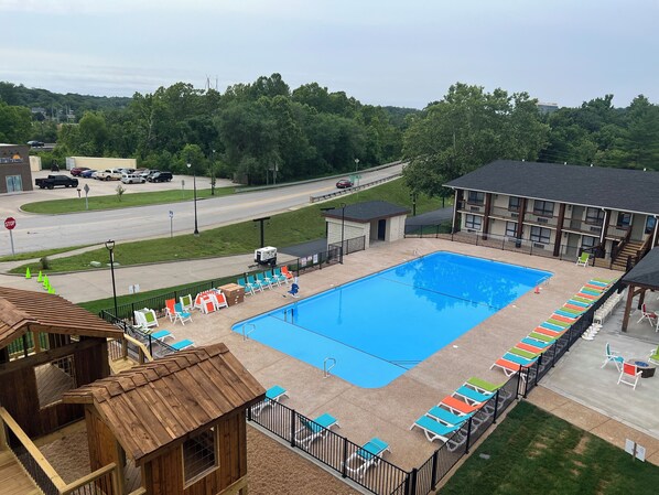 A pool area with lounge chairs and a wooden deck.