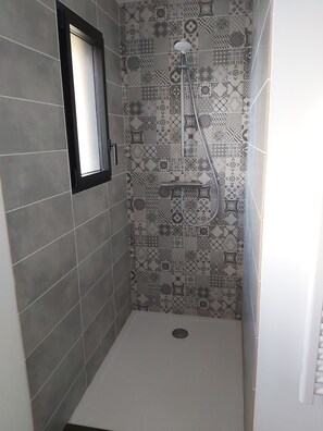 Regadera, secadora de cabello, toallas, papel de baño 